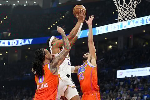 Phoenix Suns guard Jordan Goodwin, middle, shoots over Oklahoma City Thunder forward Jaylin Williams, left, and guard Ajay Mitchell, right, during the first half of an NBA Cup basketball game in Oklahoma City.