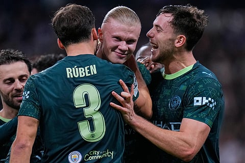 Manchester City's Erling Haaland, center, celebrates with teammates after scoring their side's second goal during a Champions League opening phase soccer match between Real Madrid and Manchester City, in Madrid, Spain.