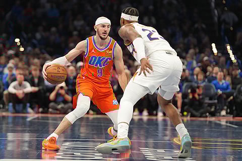 Oklahoma City Thunder guard Alex Caruso, left, looks for an opening past Phoenix Suns guard Jalen Green, right, during the second half of an NBA Cup basketball game in Oklahoma City.