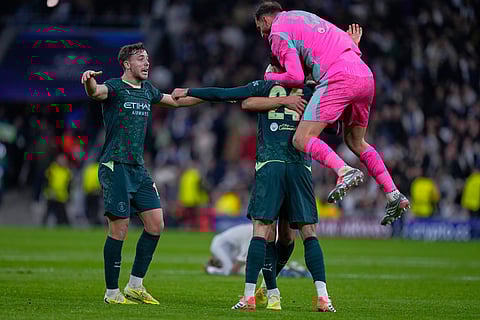 Manchester City's players celebrate at the end of a Champions League opening phase soccer match between Real Madrid and Manchester City, in Madrid, Spain.