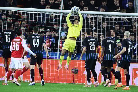 Brugge's goalkeeper Tristan van den Heuvel, center, goes up for a save during the Champions League opening phase soccer match between Club Brugge and Arsenal in Bruges, Belgium.