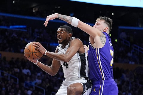 Los Angeles Lakers guard Luka Doncic (77) pressures San Antonio Spurs guard De'Aaron Fox (4) during the second half of an NBA Cup basketball game in Los Angeles. 