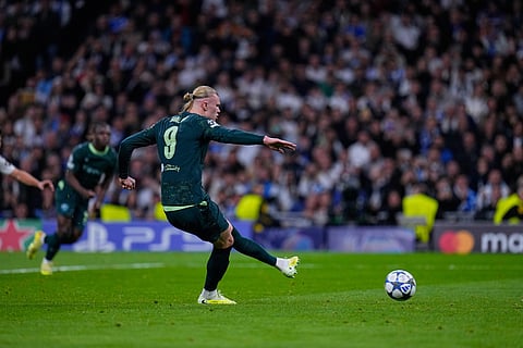 Manchester City's Erling Haaland shoots a penalty kick to score his side's second goal during a Champions League opening phase soccer match between Real Madrid and Manchester City, in Madrid, Spain.