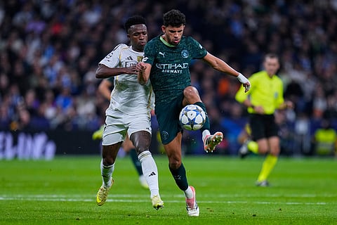 Manchester City's Matheus Nunes, right, fights for the ball with Real Madrid's Vinicius Junior during a Champions League opening phase soccer match between Real Madrid and Manchester City, in Madrid, Spain.