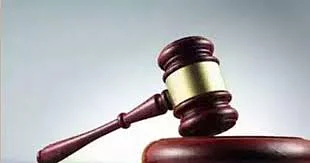 Wooden judge’s gavel resting on a sound block, symbolizing law and justice