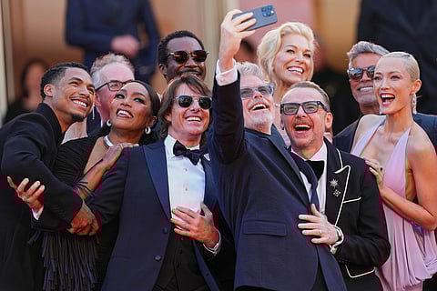 Greg Tarzan Davis, from left, editor Eddie Hamilton, Angela Bassett, Tramell Tillman, Tom Cruise, director Christopher McQuarrie, Hannah Waddingham, Simon Pegg, Esai Morales, and Pom Klementieff pose for a group selfie upon their arrival to the premiere of the film 'Mission: Impossible - The Final Reckoning' at the 78th international film festival, Cannes, southern France, May 14, 2025. 