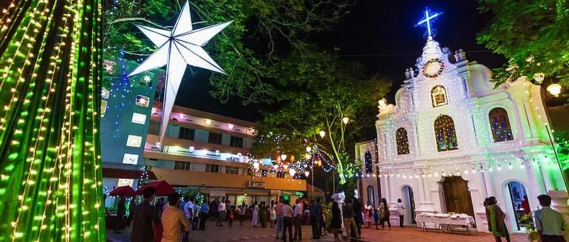 Decorated church and courtyard at night with Christmas lights