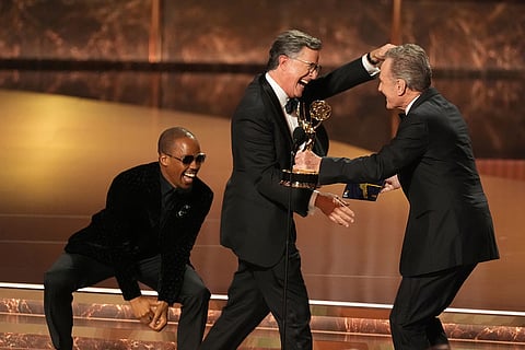 Bryan Cranston, right, presents the award for outstanding talk series to Stephen Colbert for "The Late Show with Stephen Colbert" during the 77th Primetime Emmy Awards at the Peacock Theater in Los Angeles, Sept. 14, 2025. 