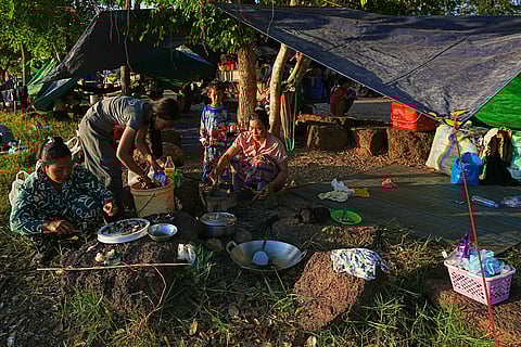 People prepare breakfast as they take refuge at Wat Chroy Neangoun's Buddhist pagoda in Siem Reap province, Cambodia after fleeing from home following fighting between Thailand and Cambodia over territorial claims. 