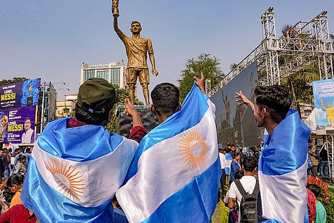 Fans cheer during the unveiling of Argentine footballer Lionel Messi's 70-feet statue, in Kolkata. Messi virtually unveiled the statue as part of his 'G.O.A.T. India Tour 2025'.