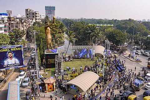 People gather near the newly unveiled 70-feet statue of Argentine footballer Lionel Messi, in Kolkata. Messi virtually unveiled the statue as part of his 'G.O.A.T. India Tour 2025'.