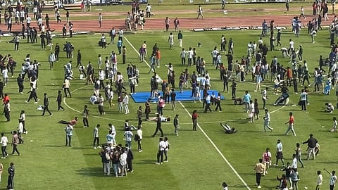 People lying down in the middle of the pitch in protest.