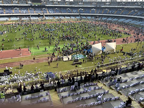 A sea of angry fans enter the pitch.