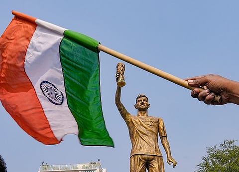 A person waves a tricolour near the newly unveiled 70-feet statue of Argentine footballer Lionel Messi, in Kolkata. Messi virtually unveiled the statue as part of his 'G.O.A.T. India Tour 2025'.