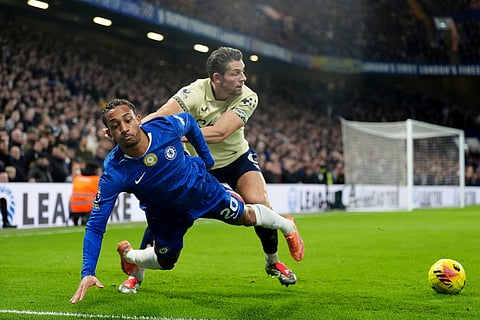 Chelsea's Joao Pedro, left, is fouled by Everton's James Tarkowski during the English Premier League soccer match between Chelsea and Everton in London.
