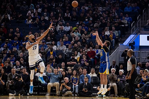Golden State Warriors guard Pat Spencer (61) shoots a three-point shot as Minnesota Timberwolves center Rudy Gobert (27) defends during the first half of their NBA basketball game in San Francisco.