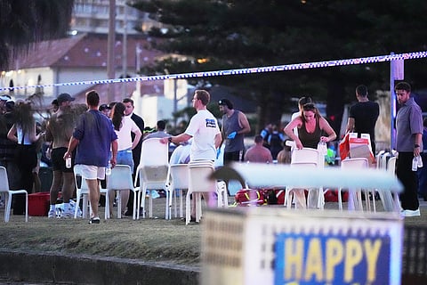 People and emergency workers gather at location where a holiday event was taking place and then a reported shooting at Bondi Beach in Sydney.
