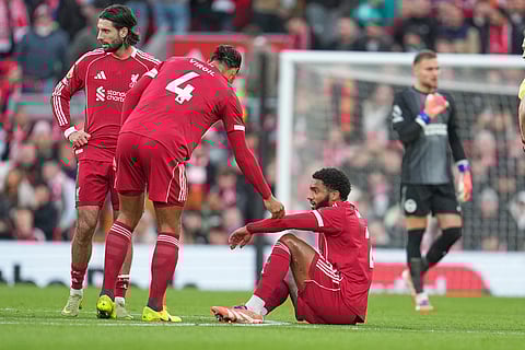 Liverpool's Virgil van Dijk assists Liverpool's Joe Gomez during the English Premier League soccer match between Liverpool and Brighton and Hove Albion in Liverpool, England.