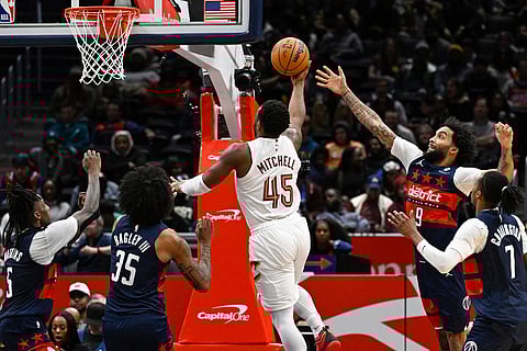 Cleveland Cavaliers guard Donovan Mitchell (45) splits the defense of the Washington Wizards to shoot during the second half of an NBA basketball game in Washington. 