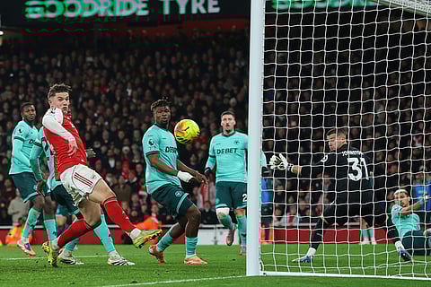Wolverhampton Wanderers' Emmanuel Agbadou, center, deflects the ball away from Arsenal's Viktor Gyoekeres, left, during the English Premier League soccer match between Arsenal and Wolves in London.