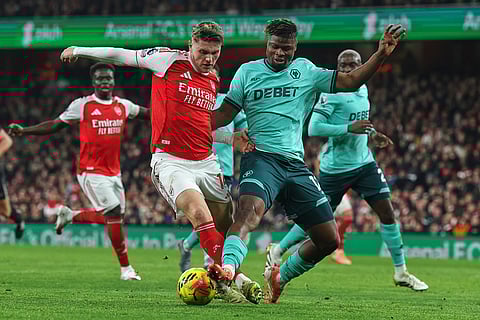 Arsenal's Viktor Gyoekeres, left, is challenged by Wolverhampton Wanderers' Emmanuel Agbadou during the English Premier League soccer match between Arsenal and Wolves in London.