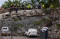 AP Photo : Rescuers search for victims after a multi-story building that was under construction collapsed on a temple below it, near the town of Verulam, north of the east coast city of Durban, South Africa, Friday, Dec. 12, 2025. 