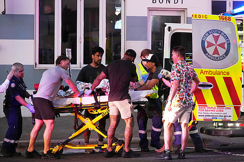 Emergency workers transport a person on a stretcher after a reported shooting at Bondi Beach in Sydney.
