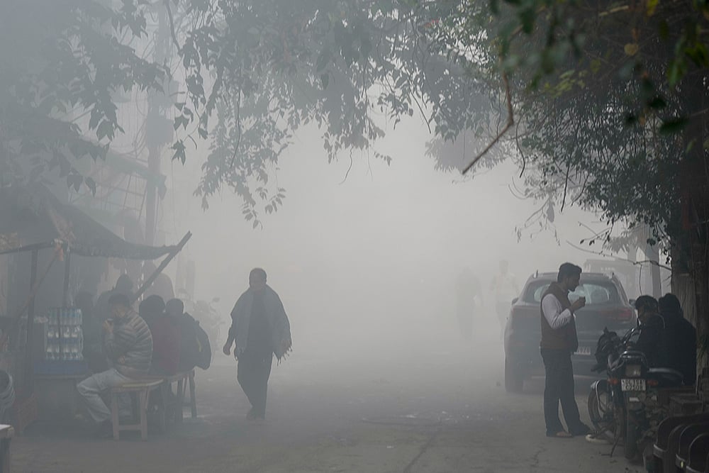 | Photo: AP/Shahbaz Khan : People have tea at a roadside stall during a cold and smoggy winter morning, in New Delhi. Delhi battled toxic fumes on Sunday as the air quality slipped into the 'severe' category with a reading of 459, according to the Central Pollution Control Board. 