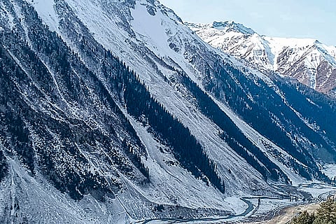 People walk along the Amarnath track as fresh snowfall blankets the area, in Baltal, Jammu and Kashmir.