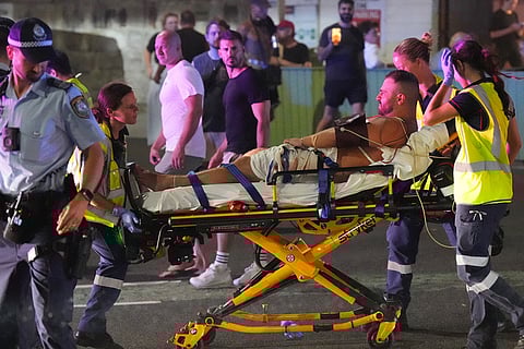 Emergency workers transport a person on a stretcher after a reported shooting at Bondi Beach in Sydney.