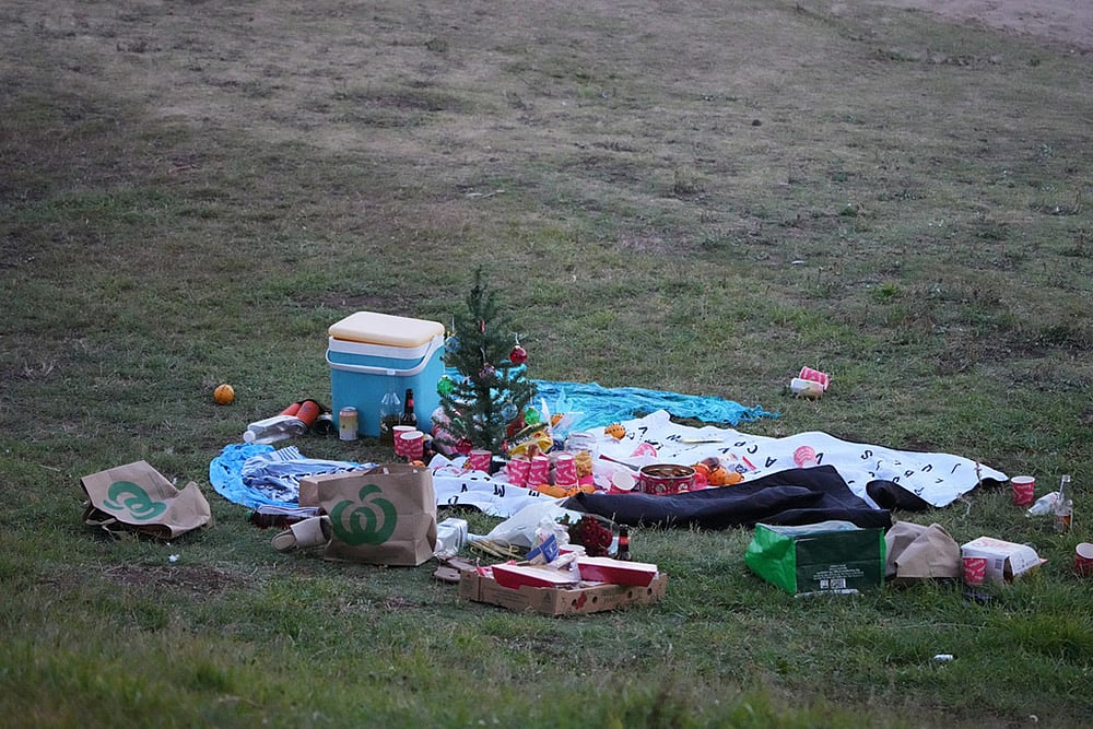 A small Christmas tree is at the center of an abandoned holiday picnic at Bondi Beach after a reported shooting in Sydney. - | Photo: AP/Mark Baker
