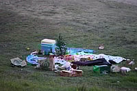 | Photo: AP/Mark Baker : A small Christmas tree is at the center of an abandoned holiday picnic at Bondi Beach after a reported shooting in Sydney.