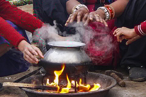 People warm their hands over a fire, on a cold winter day, in Gurugram.