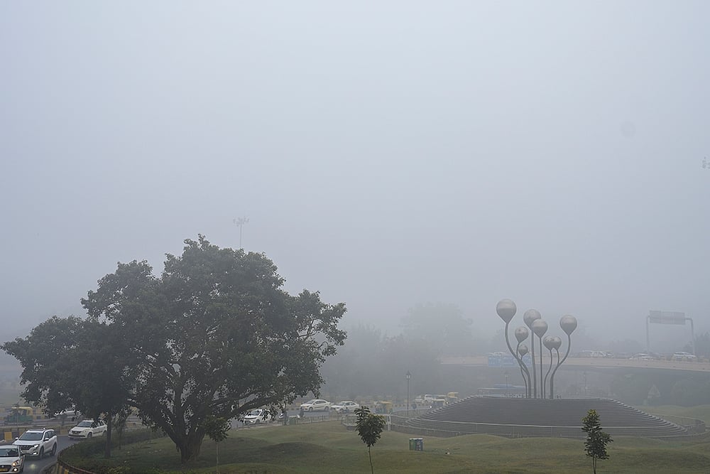 Vehicles move through fog on a cold winter morning, in New Delhi.