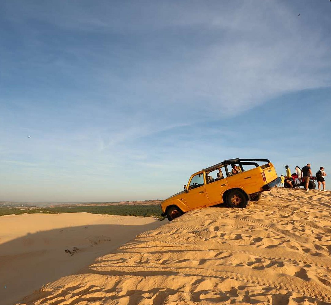 A yellow 4x4 vehicle on a large desert