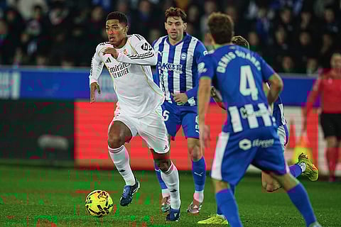 Real Madrid's Jude Bellingham, left, challenges for the ball during the Spanish La Liga soccer match between Alaves and Real Madrid in Vitoria-Gasteiz, Spain.