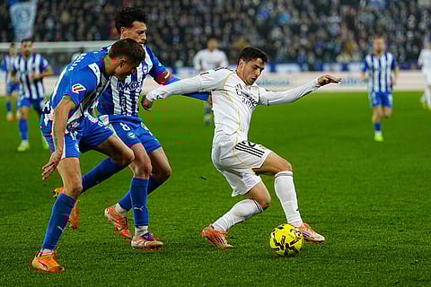 Real Madrid's Brahim Diaz, right, challenges for the ball with Alaves' Nahuel Tenaglia, left, and Antonio Blanco during the Spanish La Liga soccer match between Alaves and Real Madrid in Vitoria-Gasteiz, Spain.