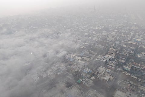 An aerial view shows the city enveloped in dense fog on a cold winter morning, in Prayagraj.