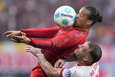 Bayern's Leroy Sane challenges for the ball with Leipzig's David Raum, bottom, during the German Bundesliga soccer match between RB Leipzig and FC Bayern Munich at the Red Bull Arena in Leipzig, Germany, May 3, 2025. 