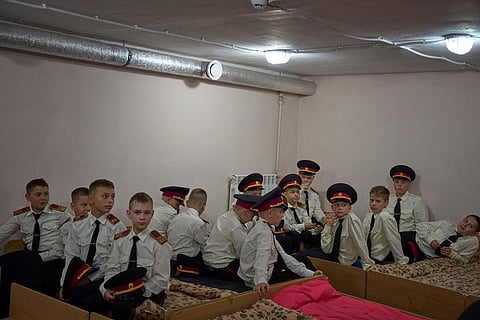 Cadets listen to their teacher as they sit in a bomb shelter on the first day at school at a cadet lyceum in Kyiv, Ukraine, Sept. 1, 2025. 