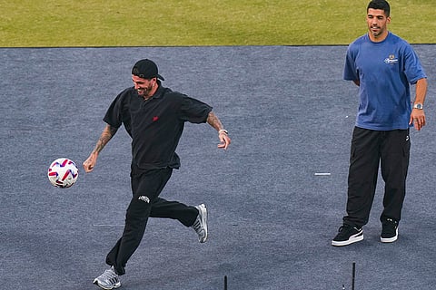 Argentine footballer Rodrigo De Paul, in black, and Uruguayan footballer Luis Suarez, in blue, during an event as part of Argentine footballer Lionel Messi's 'GOAT India Tour 2025', at Arun Jaitley Stadium in New Delhi.