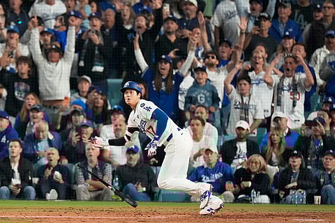 Los Angeles Dodgers' Shohei Ohtani watches his RBI-Double against the Toronto Blue Jays during the fifth inning in Game 3 of baseball's World Series, Oct. 27, 2025, in Los Angeles. 