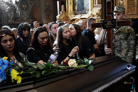 Mourners say their last goodbyes to 12 Ukrainian soldiers who died in Russian captivity during a funeral ceremony in central Lviv, Ukraine, July 25, 2025. 