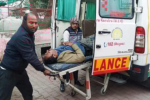 People tend to an injured passenger near an ambulance after a fog-hit pile-up involving buses and cars sparked fires on the Yamuna Expressway, in Mathura.

