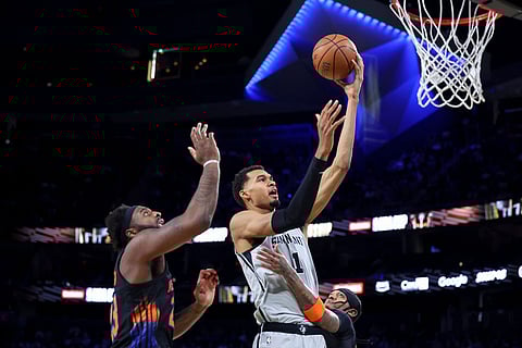 San Antonio Spurs forward Victor Wembanyama (1) shoots against New York Knicks center Mitchell Robinson (23) and guard Jordan Clarkson (00) during the first half of the NBA Cup championship basketball game in Las Vegas.