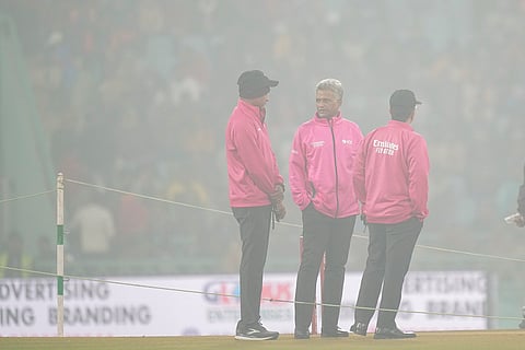 Umpires interact among themselves amid fog at Ekana Cricket Stadium ahead of the fourth T20 International cricket match of a series between India and South Africa, in Lucknow.