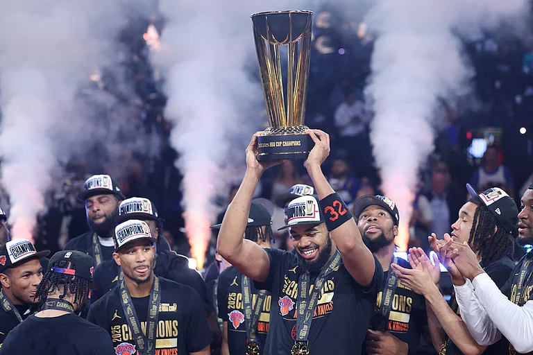 New York Knicks center Karl-Anthony Towns (32) celebrates with teammates after his team's victory against the San Antonio Spurs in the NBA Cup championship basketball game in Las Vegas. - | Photo: AP/Ian Maule