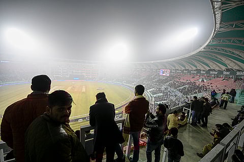 Fans look at the Ekana Cricket Stadium engulfed in fog ahead of the fourth T20 International cricket match of a series between India and South Africa, in Lucknow.