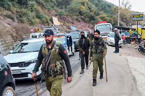 Armed security personnel patrol a busy road as forces remain on high alert and security is intensified following the Udhampur encounter, in Rajouri district, Jammu and Kashmir.