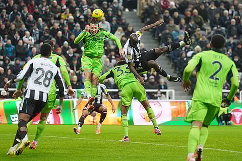 Newcastle United's Yoane Wissa, right, battles for the ball with Fulham's Sander Berge, left, and Antonee Robinson during the English League Cup quarter final soccer match between Newcastle and Fulham in Newcastle upon Tyne, England.